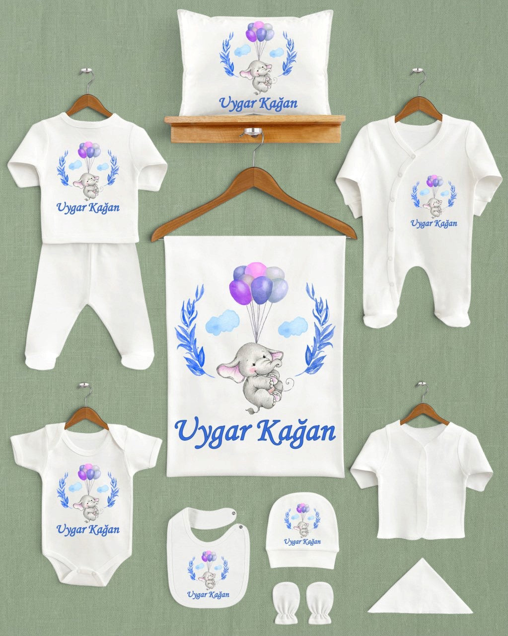 Mağazam ekru renkli, mavi yapraklı ve balon tutan fil desenli 11'li organik pamuklu yenidoğan hastane çıkış seti.